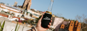 Person holding a Los Weekenders koozie overlooking a skyline