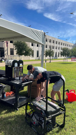 Los Weekenders employees delivering and setting up margarita machine under tent